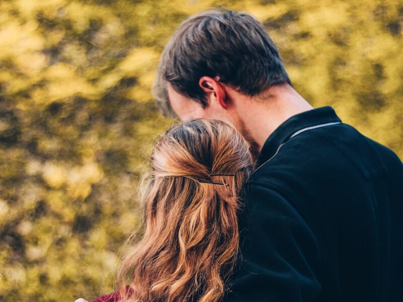 woman and man standing beside tree at daytime