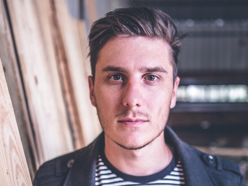 man standing beside wood planks