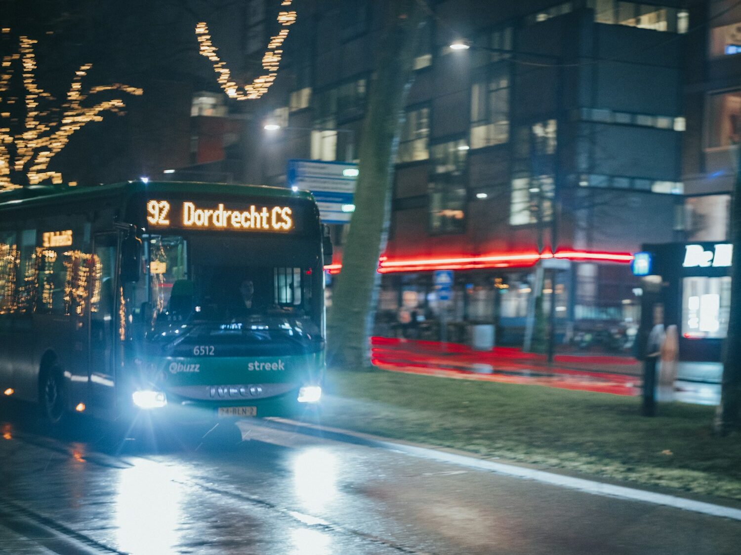 a bus driving down a street at night