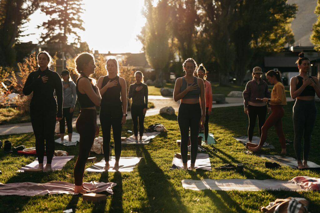 a group of people doing yoga in a park
