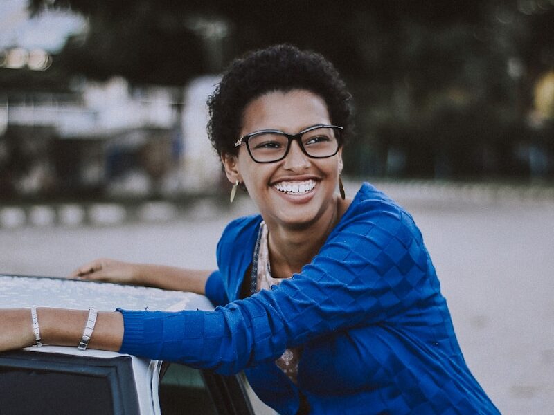 woman beside white vehicle during daytime