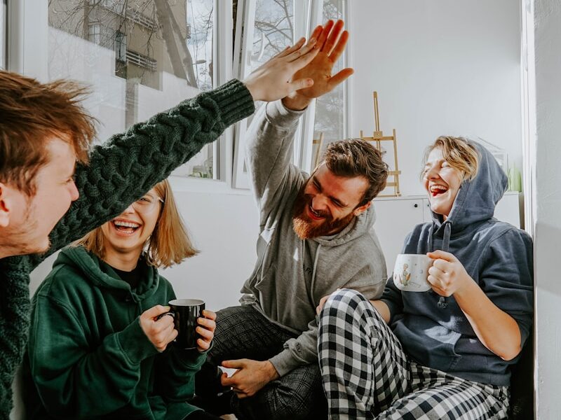 woman in black and white checkered long sleeve shirt sitting beside man in green crew neck