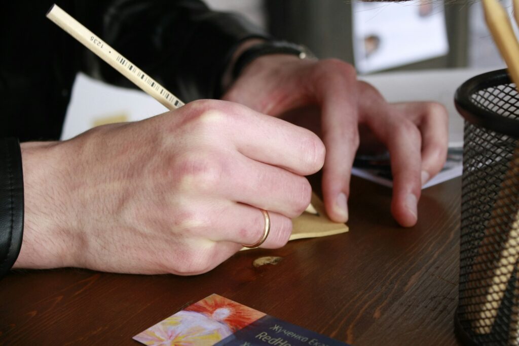 A person sitting at a desk writing on a piece of paper