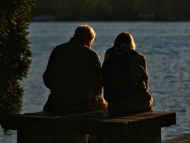 man and woman standing near body of water during daytime