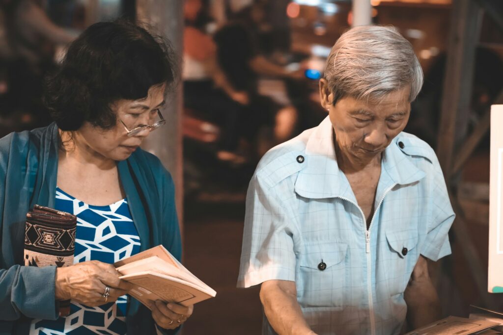 woman holding book beside man reading book