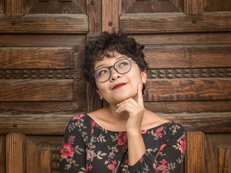 woman leaning against door while holding her cheek