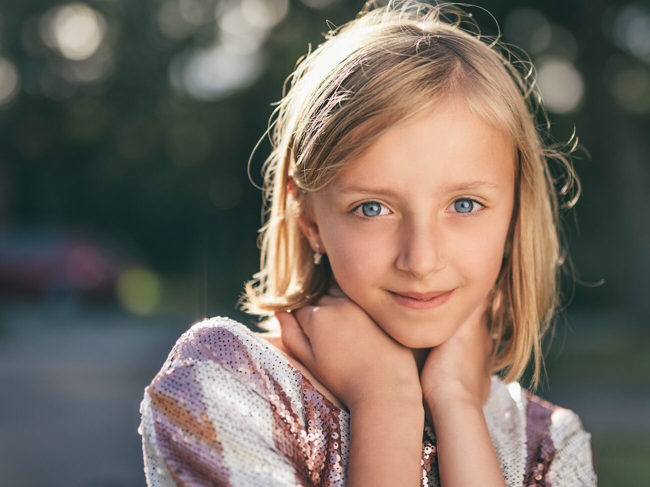 selective focus photography of girl in sequined white-and-pink stripe shirt