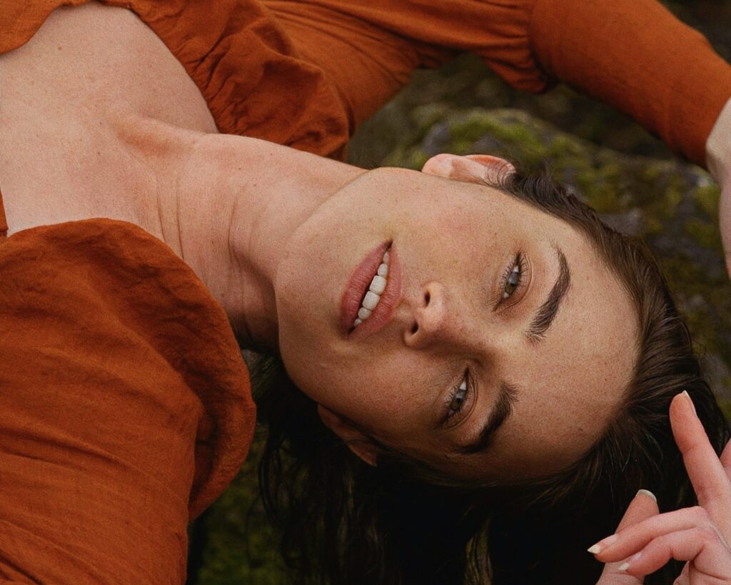 a woman laying on the ground with a peace sign in her hand