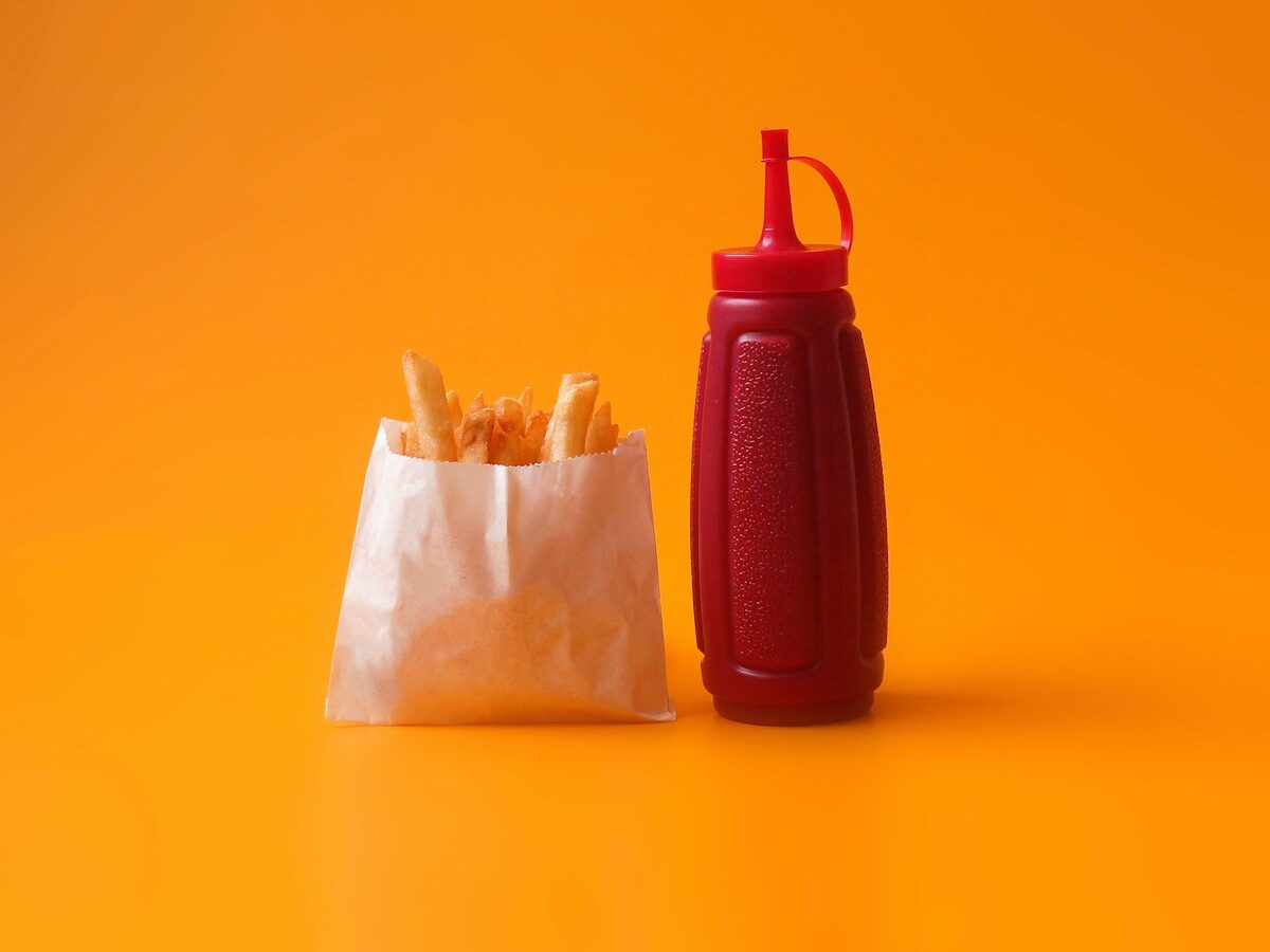 fried fries in white pack beside red squeeze bottle