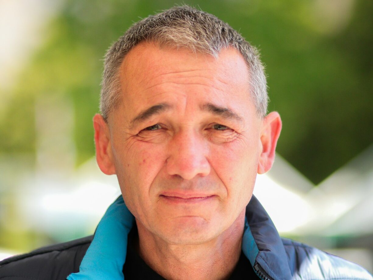 a man wearing a blue jacket and a black shirt