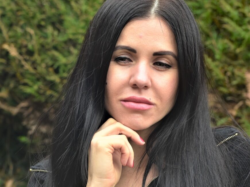 A woman with long black hair is posing for a picture