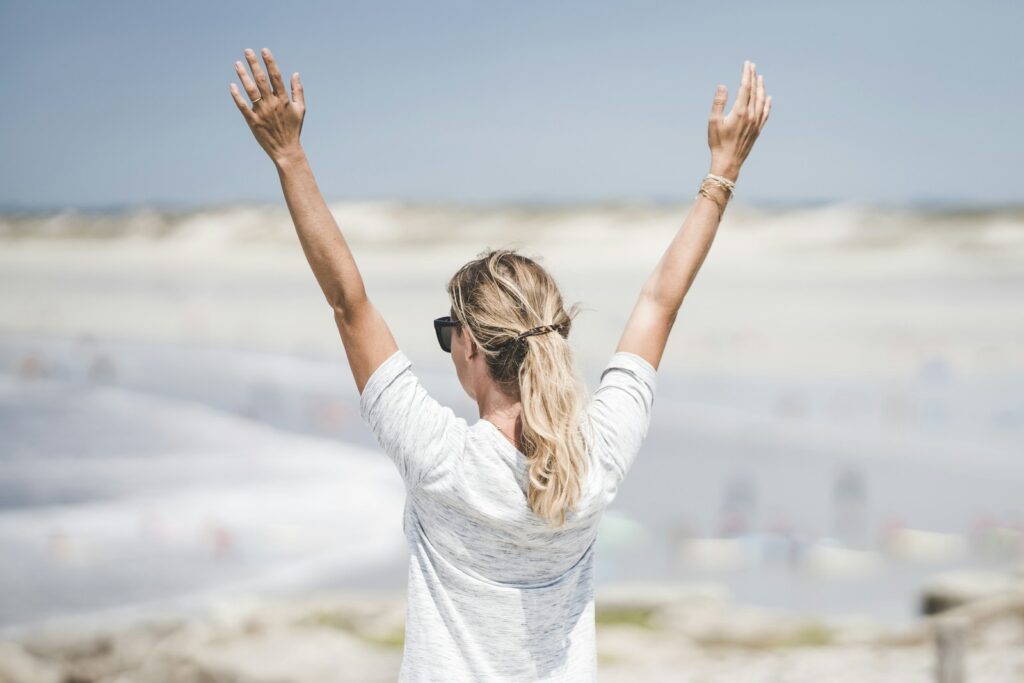 woman in white long sleeve shirt raising her hands