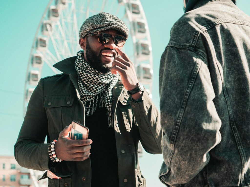 man in black coat holding white ceramic mug