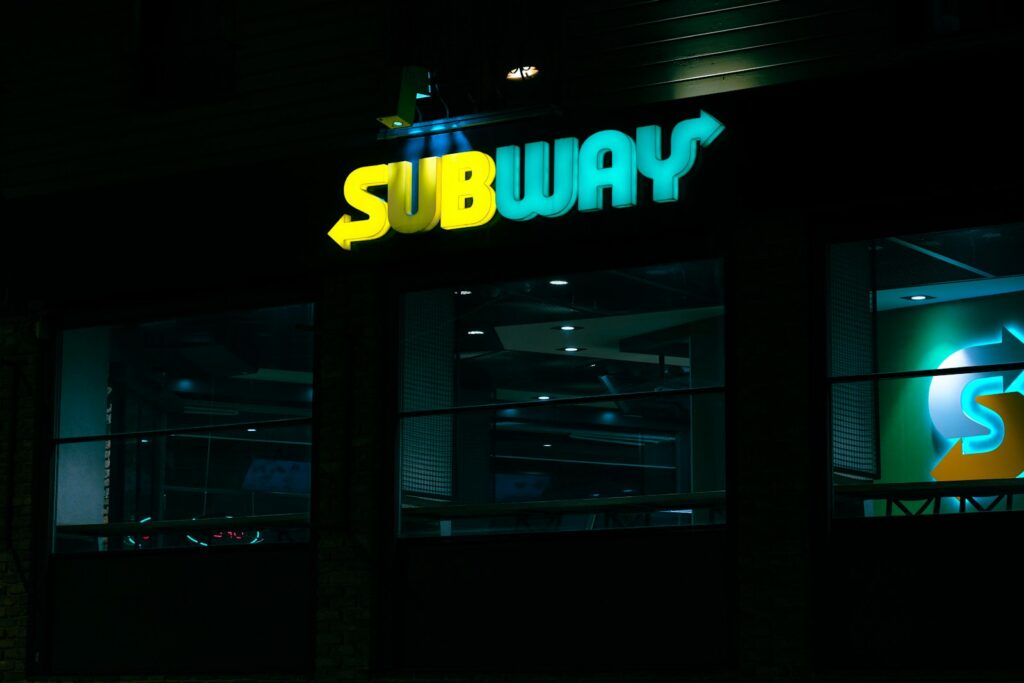 a subway sign is lit up at night