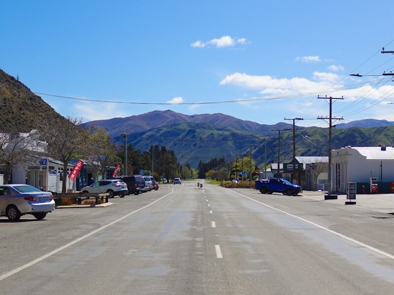 a long empty street with mountains in the background
