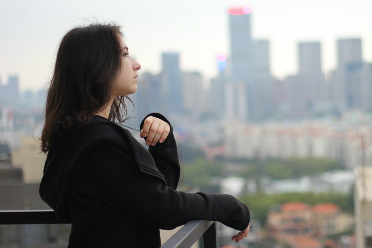 woman in black long sleeve shirt looking at the city during daytime