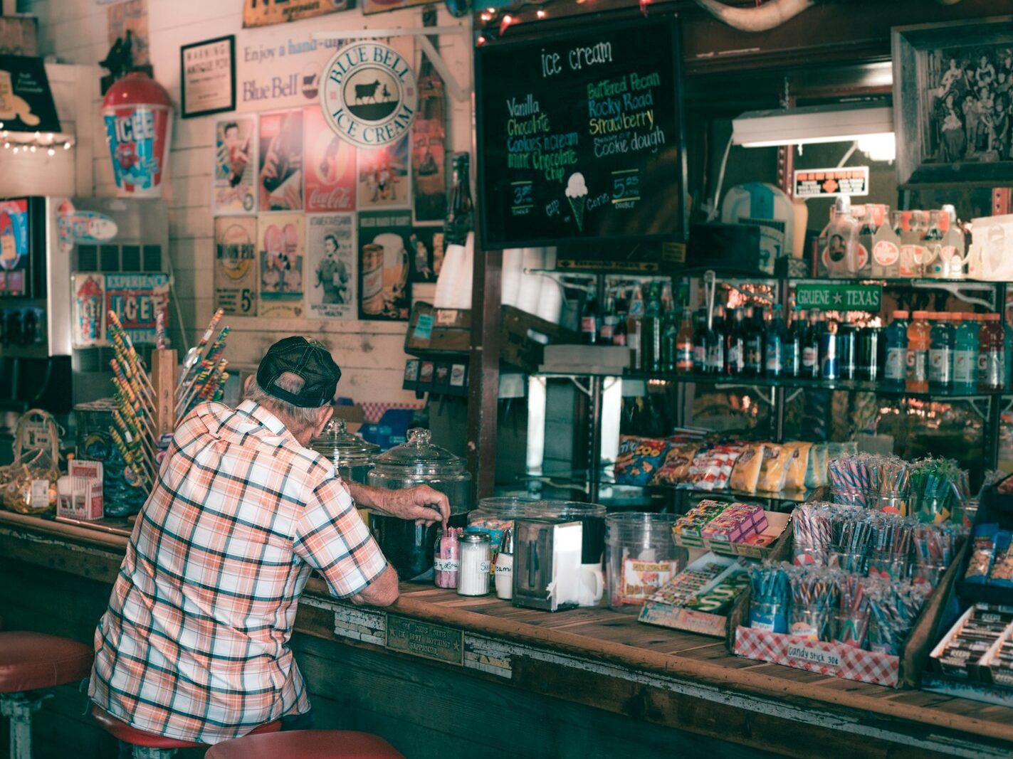 man in white and black plaid dress shirt standing in front of counter