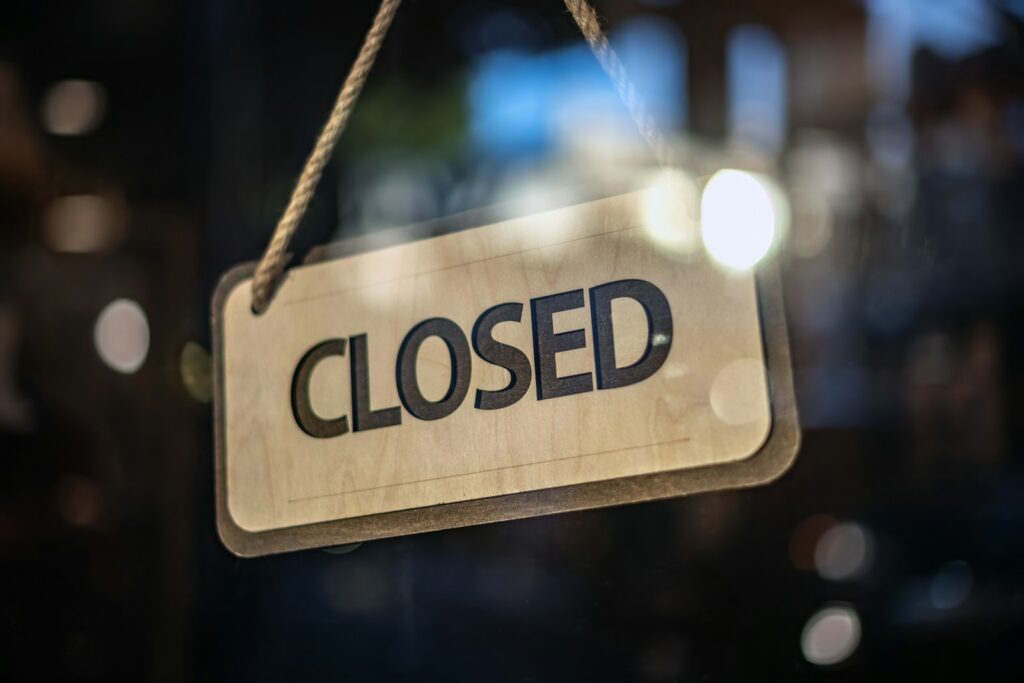A closed sign hanging from a glass door