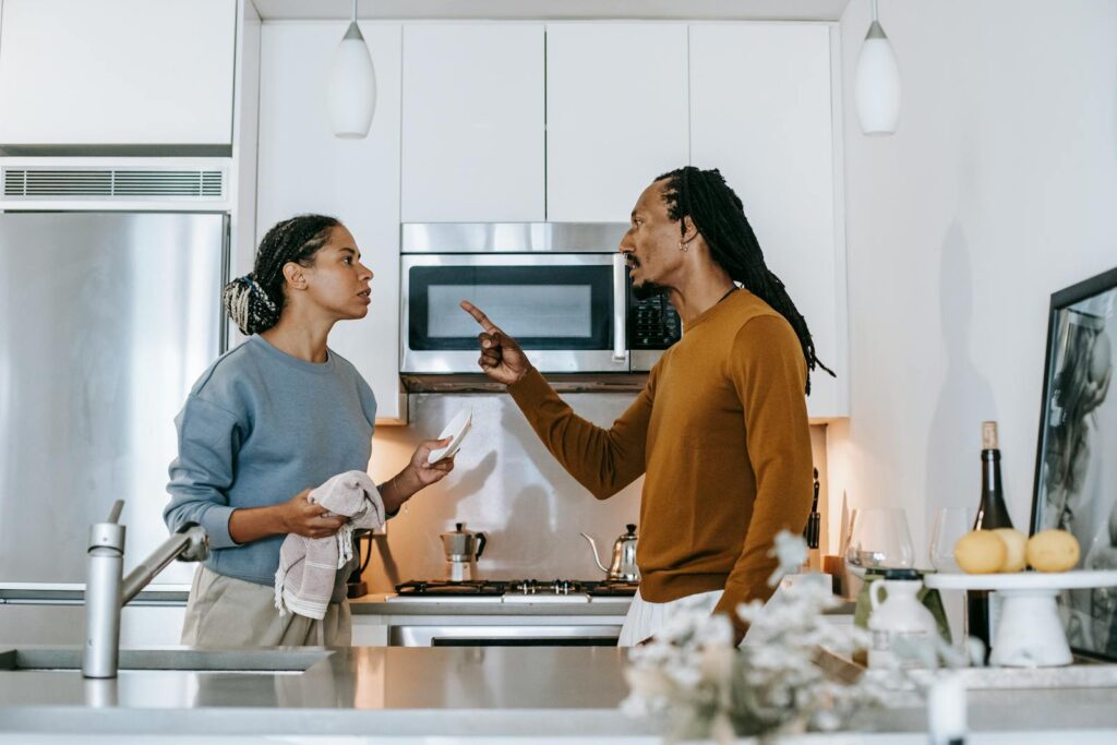 A couple in a heated discussion in a stylish kitchen, emphasizing relationship dynamics.