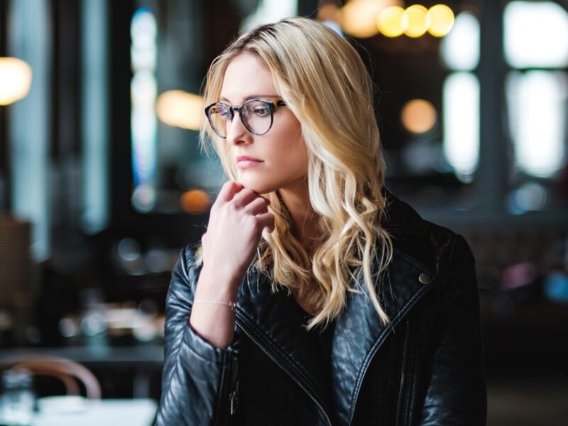 woman resting her head on her hands while looking sideways inside well lit room