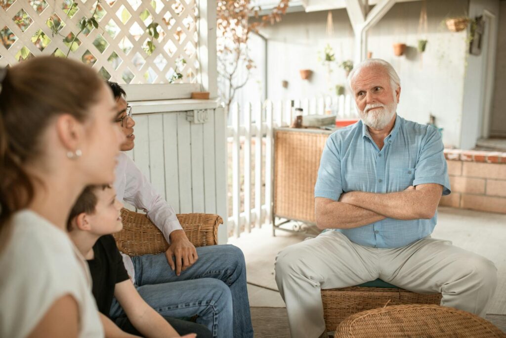 Family gathered indoors, engaged in conversation with a focus on bonds and togetherness.