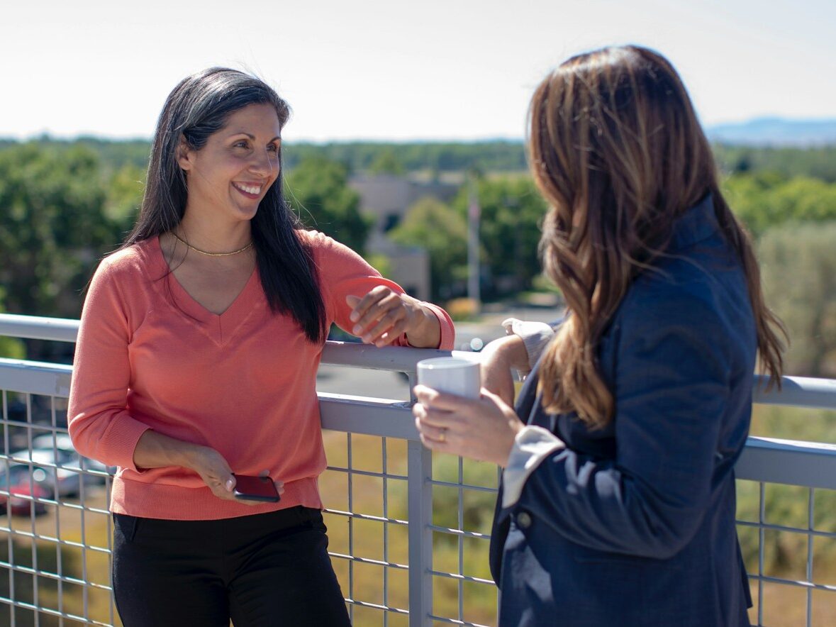 2 women standing beside railings during daytime