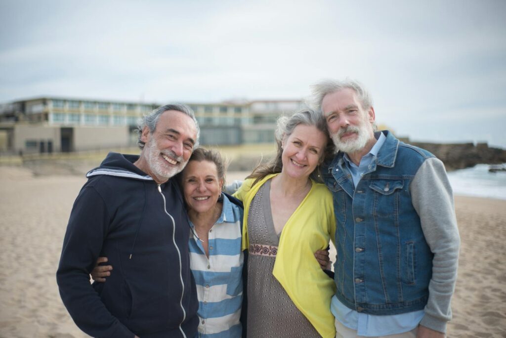 A cheerful group of mature friends enjoying a day at the beach in Portugal, showcasing togetherness.