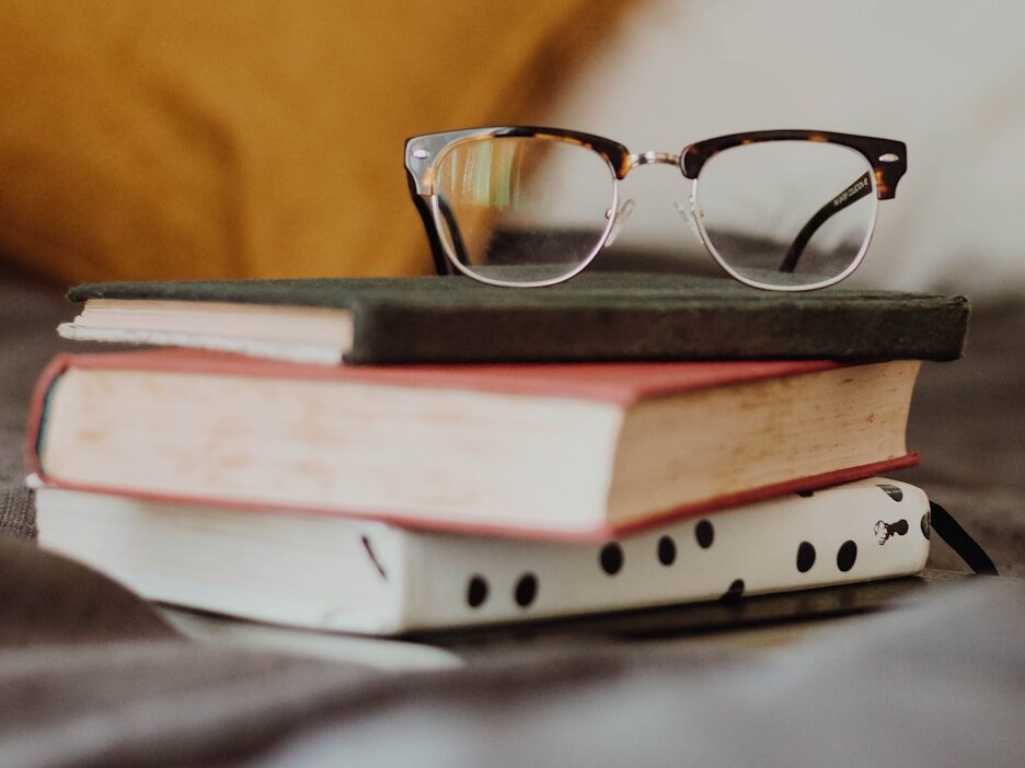 club master eyeglasses on pile of three books