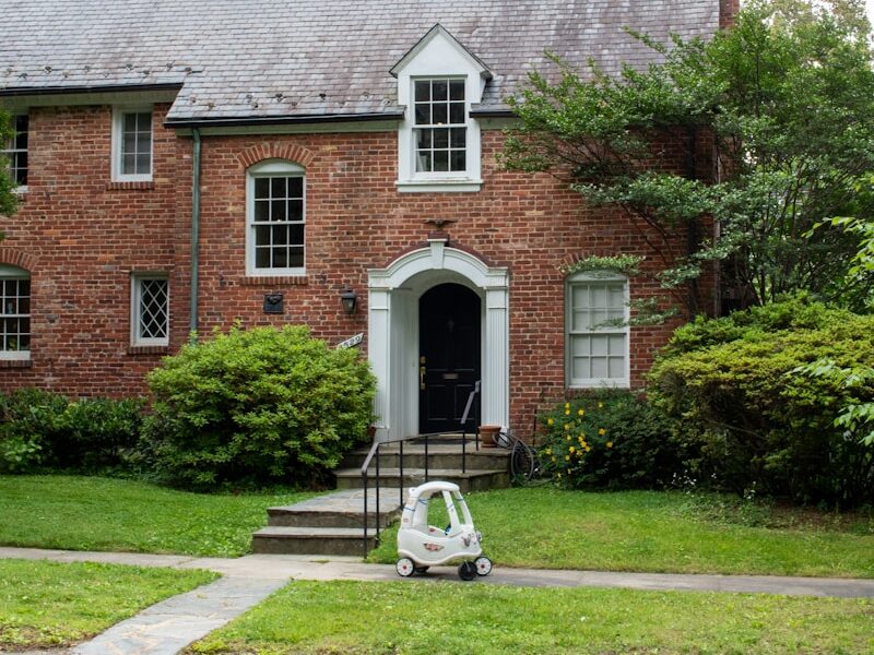 A brick house with a car parked in front of it