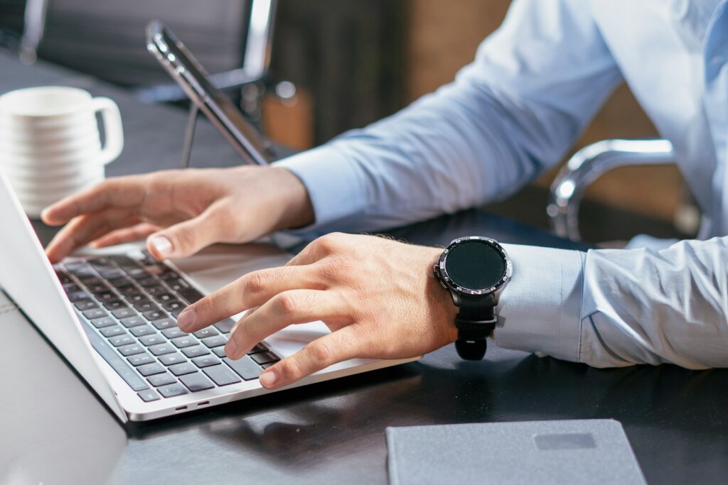 A person typing on a laptop at a desk