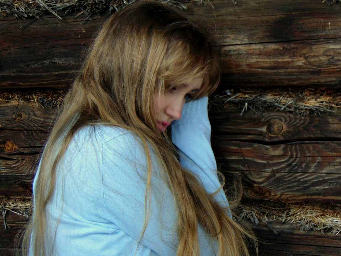 woman leaning on black wooden wall
