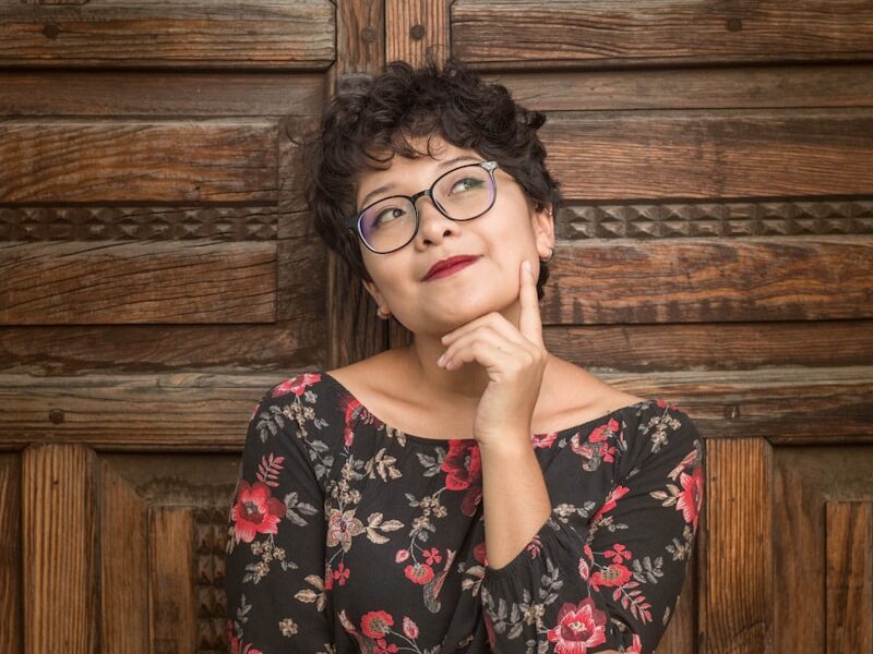 woman leaning against door while holding her cheek