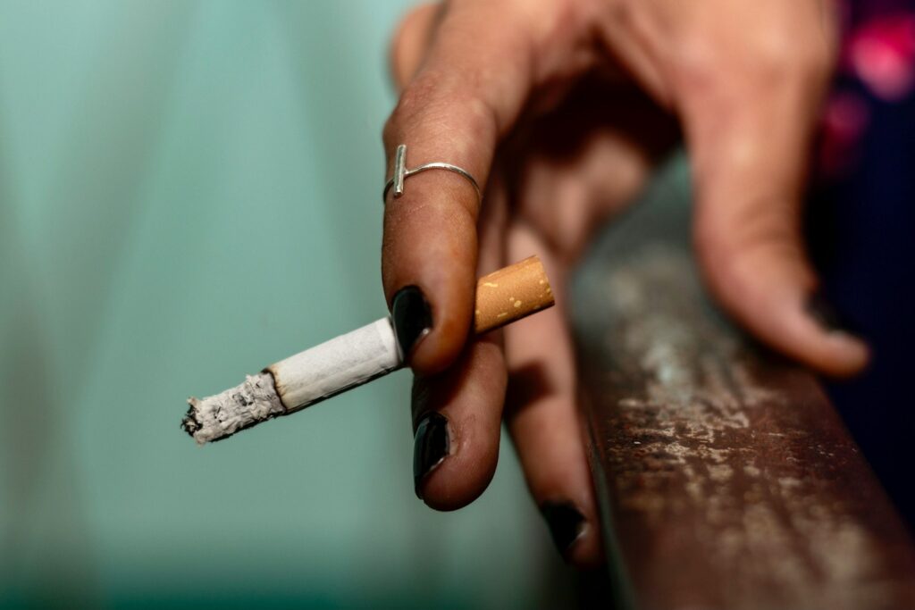 a person holding a cigarette in their hand