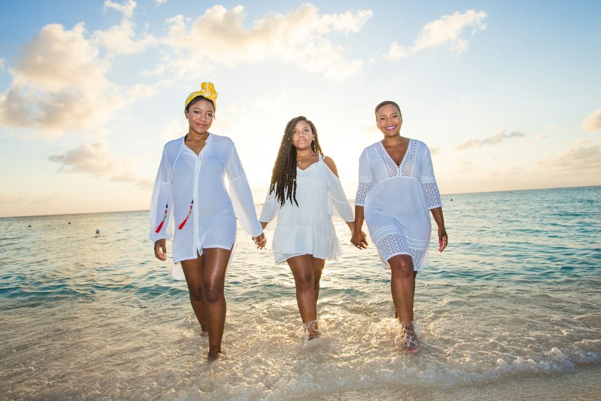 three women holding hands in seashore