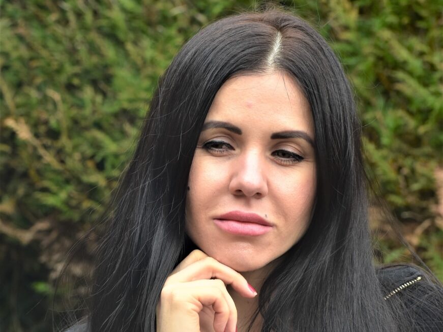 A woman with long black hair is posing for a picture