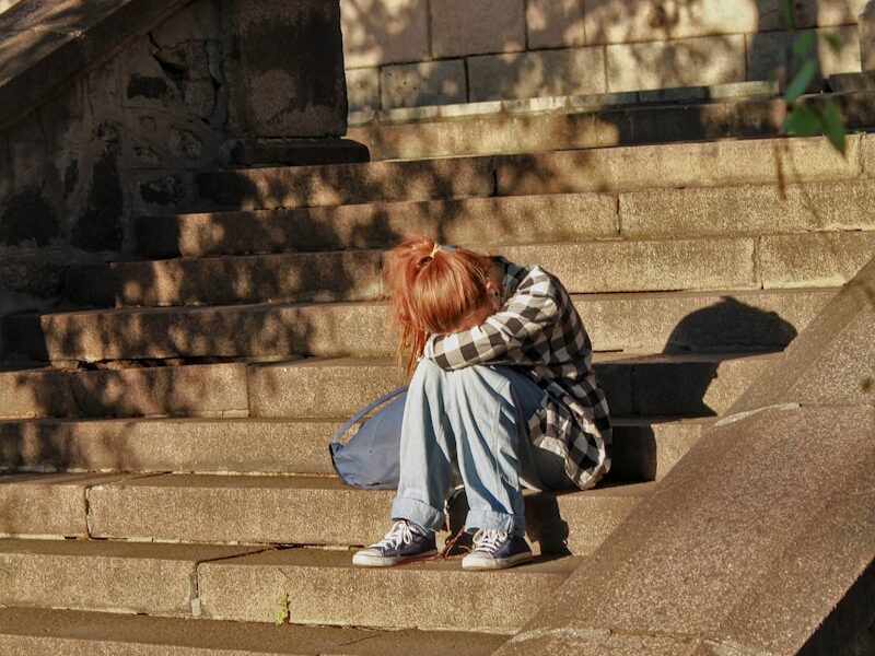 woman in black and white dress sitting on concrete stairs