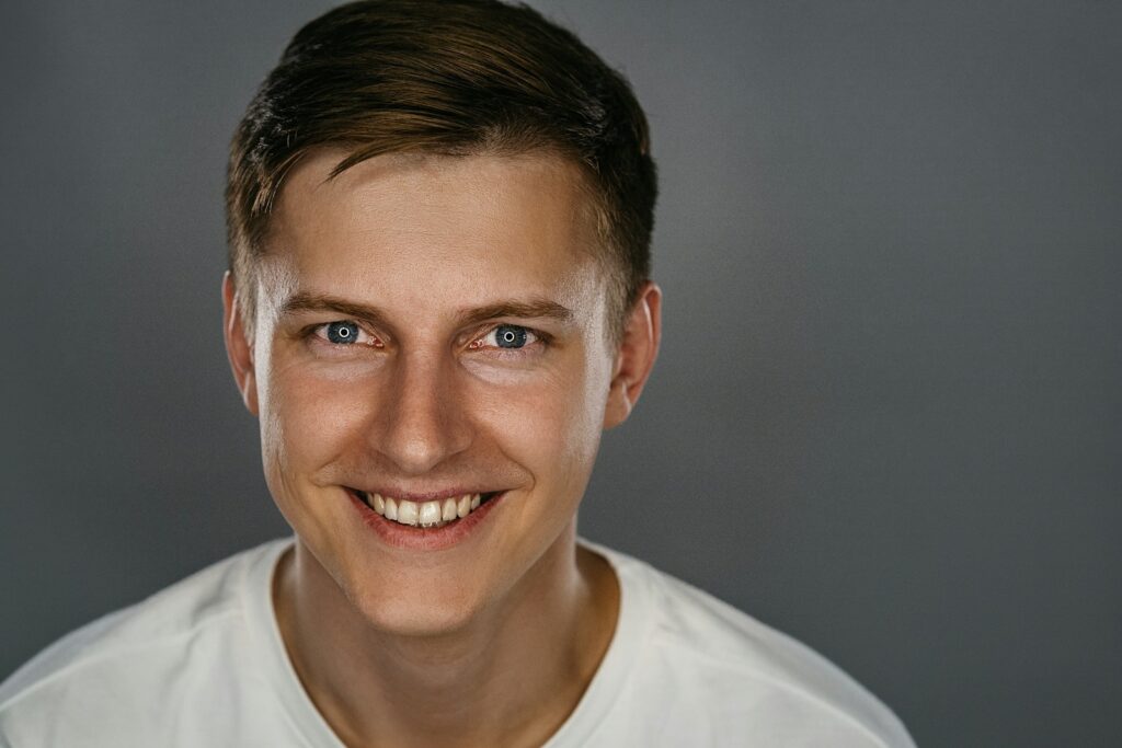 man in white crew neck shirt smiling