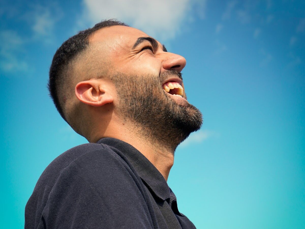 smiling man wearing black collared top
