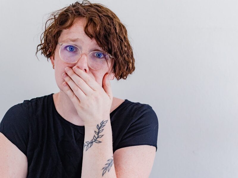 a woman covers her mouth with her hands