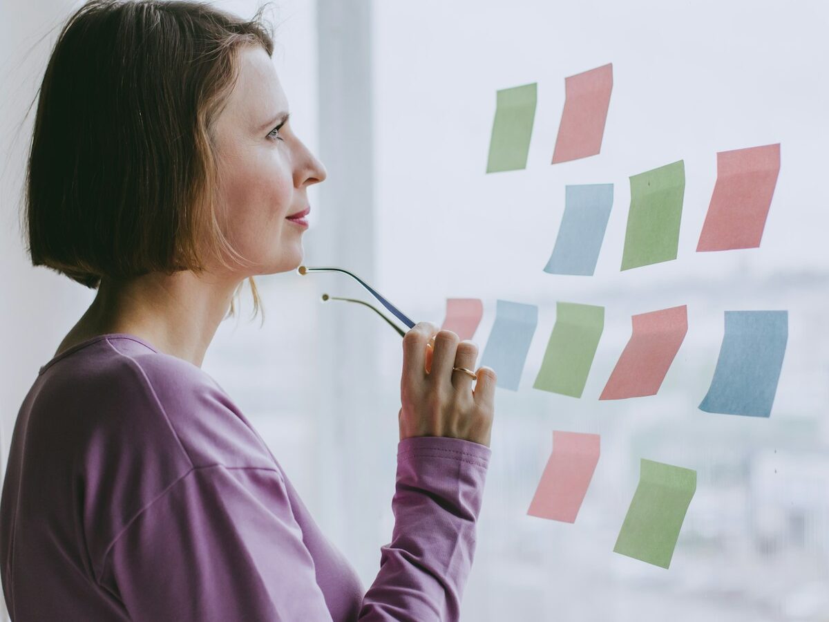 a woman looking out a window with sticky notes on it