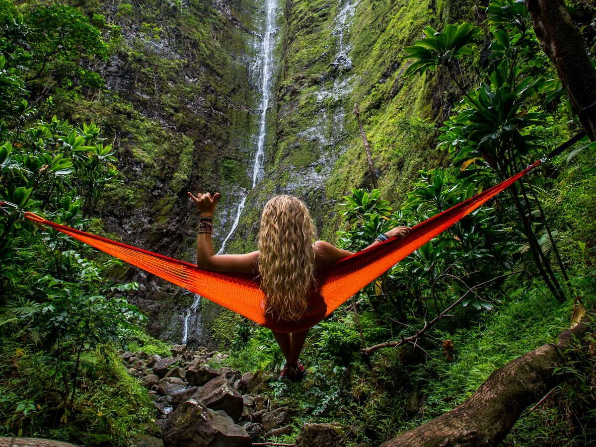 woman on hammock facing waterfalls