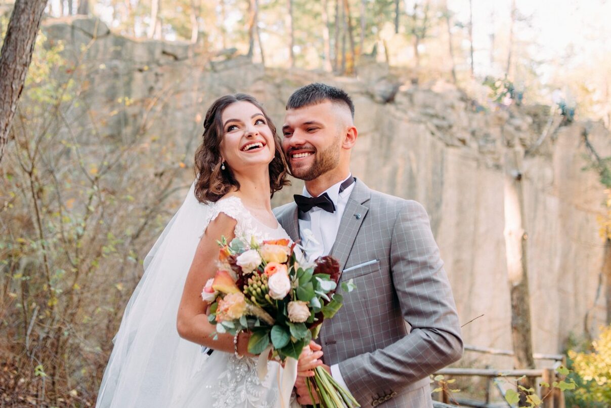 man and woman both laughing by tree during daytime