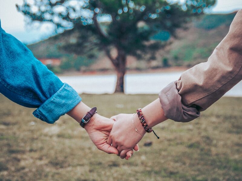 two persons holding hands